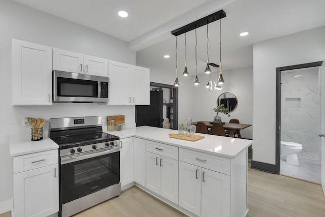 1195 E Whittier St, Columbus, OH 43206 - kitchen featuring stainless steel appliances, a peninsula, white cabinetry, light countertops, and recessed lighting