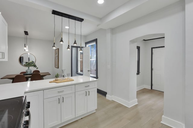 1195 E Whittier St, Columbus, OH 43206 - kitchen featuring stainless steel electric stove, white cabinetry, arched walkways, light wood-style floors, and light countertops
