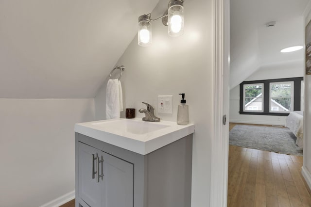 1195 E Whittier St, Columbus, OH 43206 - bathroom featuring lofted ceiling, vanity, hardwood / wood-style flooring, and baseboards