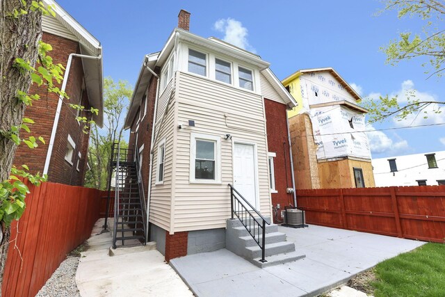 1195 E Whittier St, Columbus, OH 43206 - rear view of house with entry steps, a chimney, and stairs