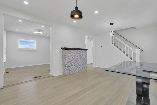 841 Saint Clair Ave, Columbus, OH 43201 - unfurnished living room with wood finished floors, stairway, baseboards, and recessed lighting