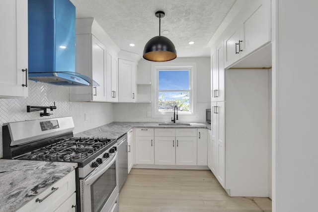 841 Saint Clair Ave, Columbus, OH 43201 - kitchen with appliances with stainless steel finishes, wall chimney exhaust hood, a sink, white cabinets, and light stone countertops