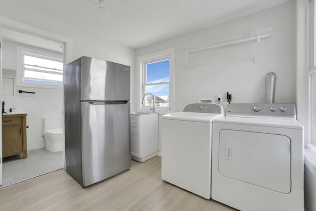 841 Saint Clair Ave, Columbus, OH 43201 - clothes washing area with washer and clothes dryer, healthy amount of natural light, and light wood-type flooring