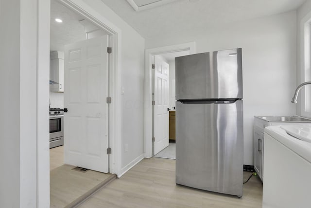 841 Saint Clair Ave, Columbus, OH 43201 - laundry area featuring light wood finished floors, washer / dryer, and baseboards