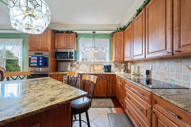 7563 Jenkins Dr, Canal Winchester, OH 43110 - kitchen featuring stainless steel appliances, brown cabinets, a breakfast bar area, light stone counters, and crown molding