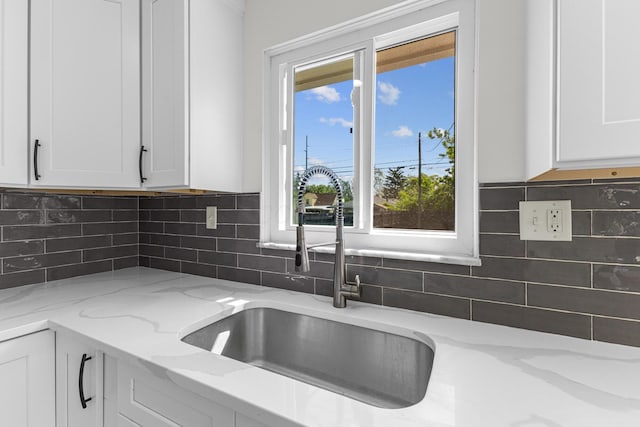 270 S Kellner Rd, Columbus, OH 43209 - kitchen with a sink, white cabinets, light stone counters, and decorative backsplash