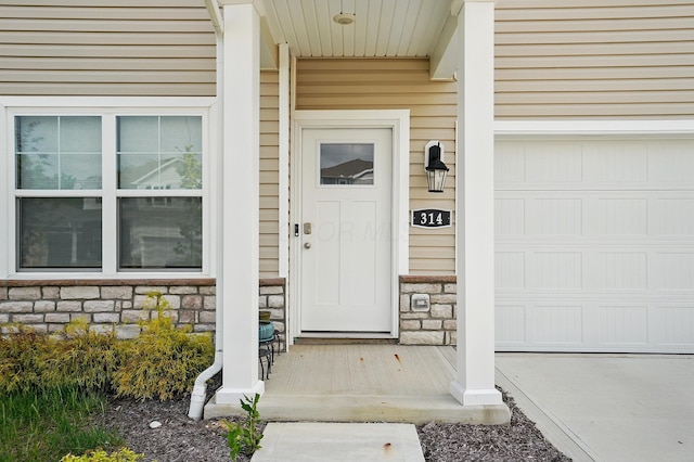 314 Sandburg Dr, Lithopolis, OH 43136 - doorway to property with stone siding, a garage, and covered porch