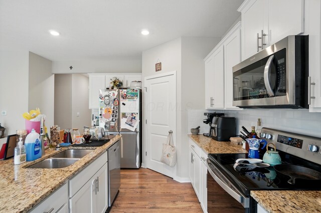 314 Sandburg Dr, Lithopolis, OH 43136 - kitchen with stainless steel appliances, backsplash, light wood-style floors, white cabinets, and recessed lighting