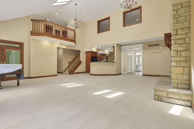 1200 Willow Rd, Springfield, OH 45502 - unfurnished living room with light colored carpet, a chandelier, baseboards, and high vaulted ceiling