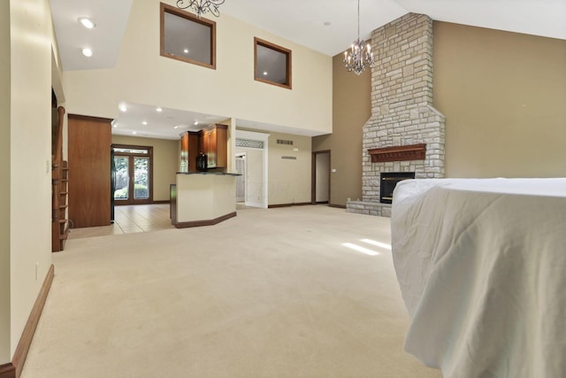 1200 Willow Rd, Springfield, OH 45502 - living area featuring high vaulted ceiling, a chandelier, light carpet, a stone fireplace, and baseboards
