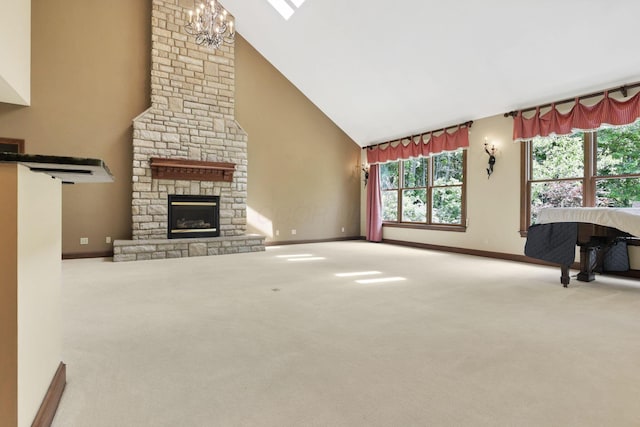 1200 Willow Rd, Springfield, OH 45502 - unfurnished living room with high vaulted ceiling, baseboards, a stone fireplace, carpet, and a chandelier