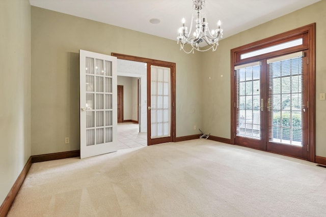 1200 Willow Rd, Springfield, OH 45502 - spare room featuring french doors, a chandelier, light colored carpet, and baseboards