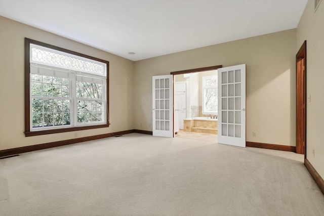 1200 Willow Rd, Springfield, OH 45502 - spare room featuring french doors, light carpet, and baseboards
