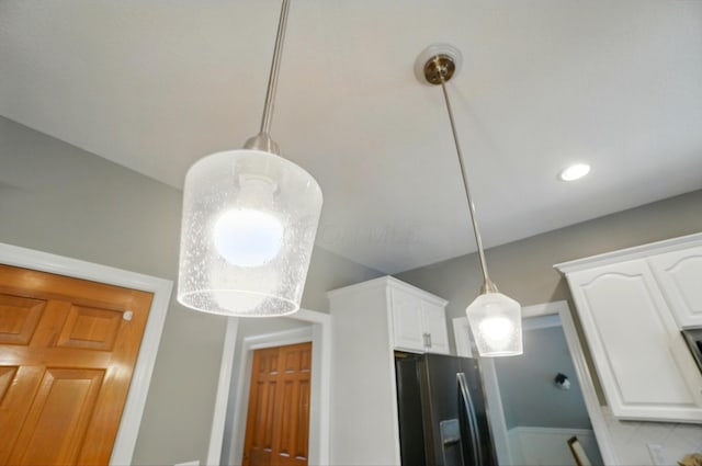5741 Ridgewood Ave, Westerville, OH 43082 - kitchen view of fridge with ice dispenser, white cabinetry, and hanging light fixtures
