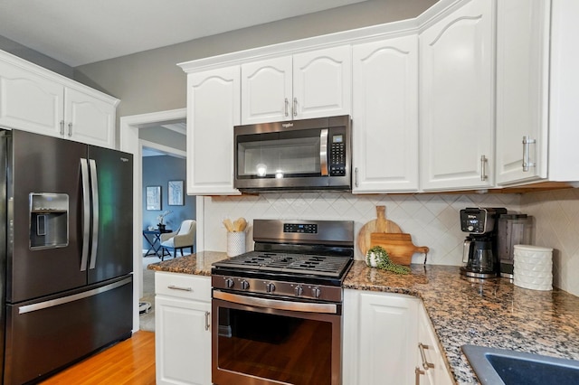 5741 Ridgewood Ave, Westerville, OH 43082 - kitchen featuring appliances with stainless steel finishes, white cabinetry, dark stone countertops, and tasteful backsplash