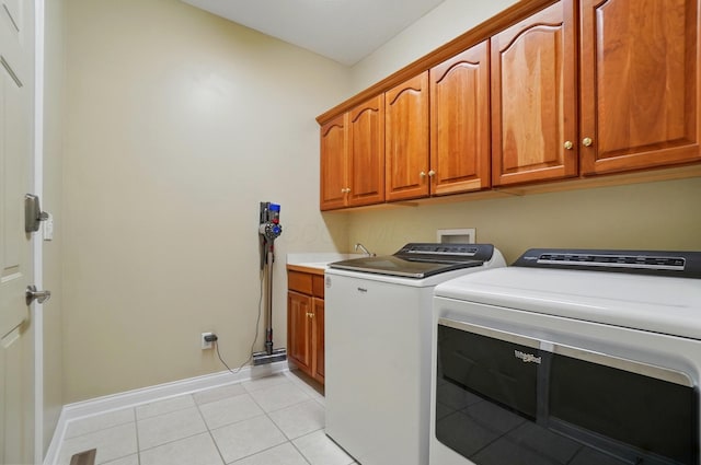 5741 Ridgewood Ave, Westerville, OH 43082 - washroom featuring cabinet space, washing machine and dryer, light tile patterned flooring, and baseboards