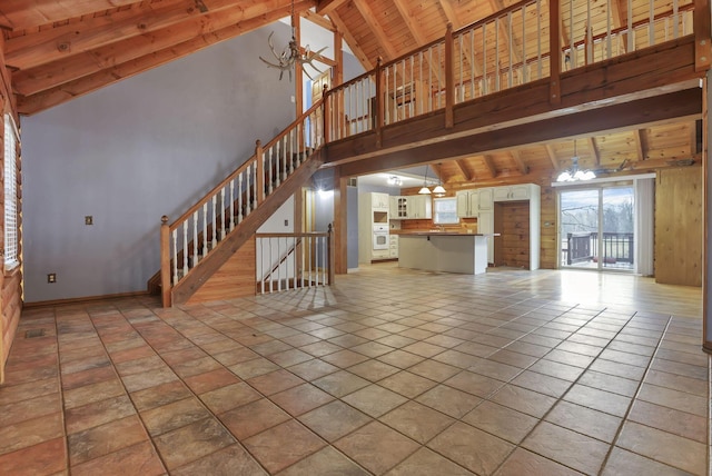 7760 Township Rd 177, Fredericktown, OH 43019 - unfurnished living room featuring a chandelier, wood ceiling with exposed beams, high vaulted ceiling, stairs, and baseboards