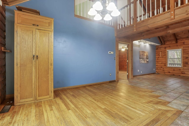 7760 Township Rd 177, Fredericktown, OH 43019 - unfurnished living room with a chandelier, baseboards, beamed ceiling, light wood-style flooring, and high vaulted ceiling