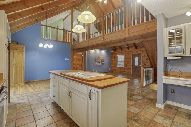 7760 Township Rd 177, Fredericktown, OH 43019 - kitchen with wood walls, a chandelier, light stone finish floors, baseboards, and a center island