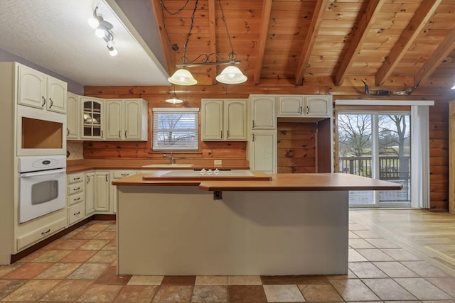 7760 Township Rd 177, Fredericktown, OH 43019 - kitchen featuring oven, wooden ceiling, a center island, wooden walls, and decorative light fixtures