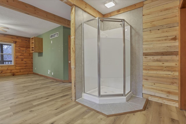 7760 Township Rd 177, Fredericktown, OH 43019 - bathroom featuring wood finished floors, a stall shower, beamed ceiling, and wooden walls