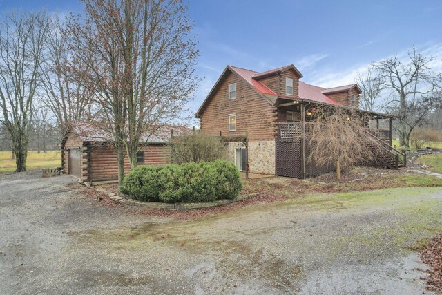 7760 Township Rd 177, Fredericktown, OH 43019 - view of property exterior featuring log siding, a porch, dirt driveway, and stairway
