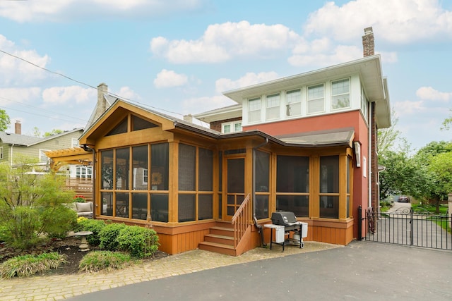 2454 Seneca Park Pl, Columbus, OH 43209 - rear view of property featuring a sunroom, a chimney, and a gate