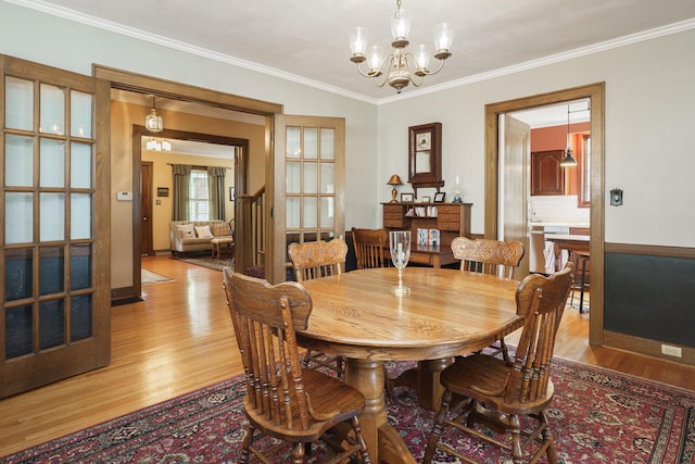 2454 Seneca Park Pl, Columbus, OH 43209 - dining area with light wood finished floors, ornamental molding, a chandelier, and baseboards