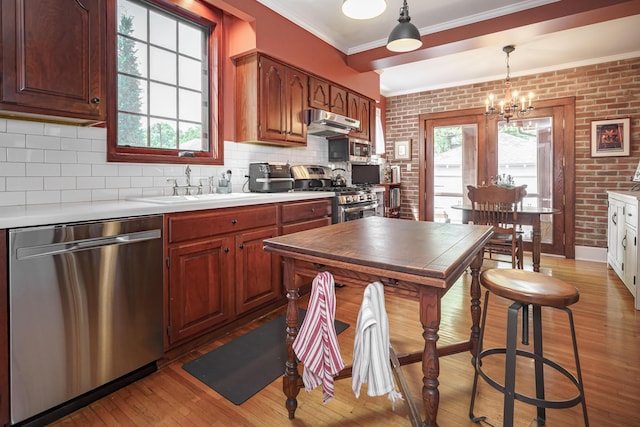 2454 Seneca Park Pl, Columbus, OH 43209 - kitchen featuring stainless steel appliances, a sink, light wood-style floors, crown molding, and a chandelier