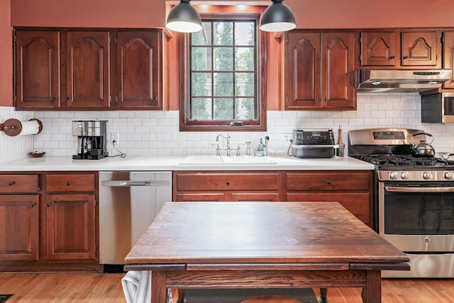 2454 Seneca Park Pl, Columbus, OH 43209 - kitchen featuring stainless steel appliances, under cabinet range hood, a sink, backsplash, and light countertops