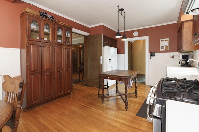 2454 Seneca Park Pl, Columbus, OH 43209 - kitchen featuring gas stove, light wood-style floors, wainscoting, white refrigerator with ice dispenser, and a sink