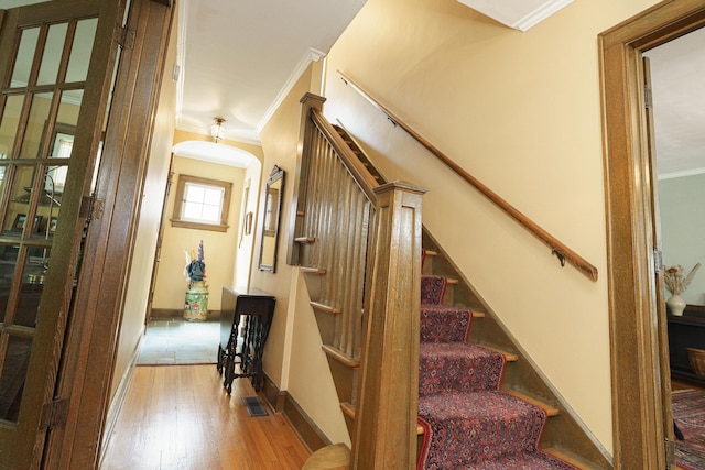 2454 Seneca Park Pl, Columbus, OH 43209 - stairway with ornamental molding, wood-type flooring, arched walkways, and baseboards