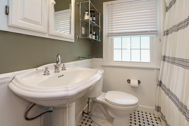 2454 Seneca Park Pl, Columbus, OH 43209 - bathroom with toilet, a shower with curtain, a sink, baseboards, and a wainscoted wall
