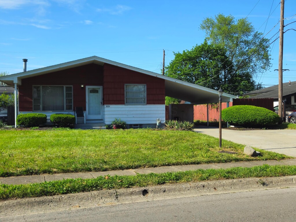 3084 Clermont Rd, Columbus, OH 43227 - view of front of house with a front lawn, concrete driveway, a carport, and entry steps
