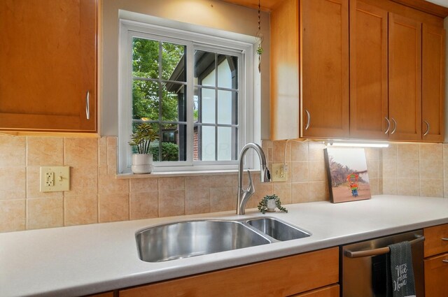 127 Saint Michelle St Unit 35B, Columbus, OH 43085 - kitchen with dishwasher, a sink, light countertops, brown cabinets, and backsplash