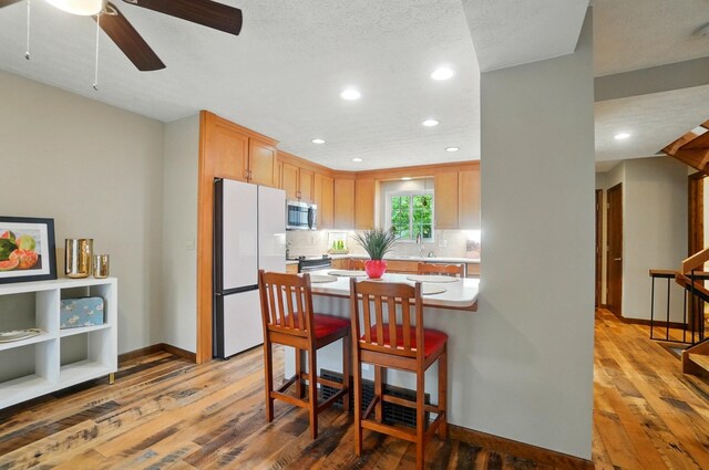 127 Saint Michelle St Unit 35B, Columbus, OH 43085 - kitchen with appliances with stainless steel finishes, light wood-type flooring, light countertops, baseboards, and tasteful backsplash