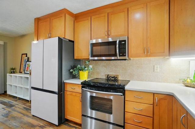 127 Saint Michelle St Unit 35B, Columbus, OH 43085 - kitchen with stainless steel appliances, dark wood-type flooring, light countertops, tasteful backsplash, and brown cabinets