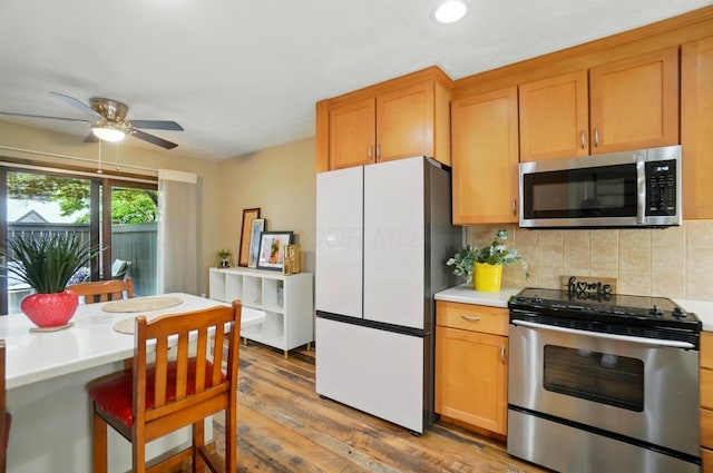 127 Saint Michelle St Unit 35B, Columbus, OH 43085 - kitchen with stainless steel appliances, light countertops, decorative backsplash, light wood-style floors, and ceiling fan