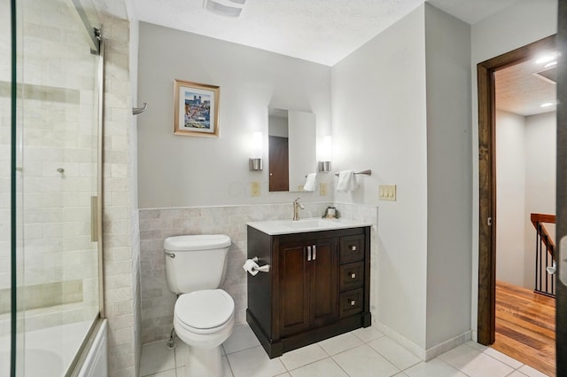 127 Saint Michelle St Unit 35B, Columbus, OH 43085 - full bath with tile patterned floors, toilet, vanity, tile walls, and combined bath / shower with glass door
