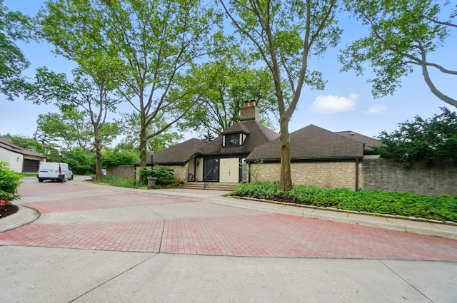 127 Saint Michelle St Unit 35B, Columbus, OH 43085 - mid-century inspired home featuring decorative driveway, a chimney, stone siding, and roof with shingles