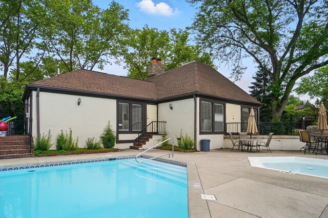 127 Saint Michelle St Unit 35B, Columbus, OH 43085 - rear view of property with stucco siding, a chimney, a community pool, a patio, and roof with shingles