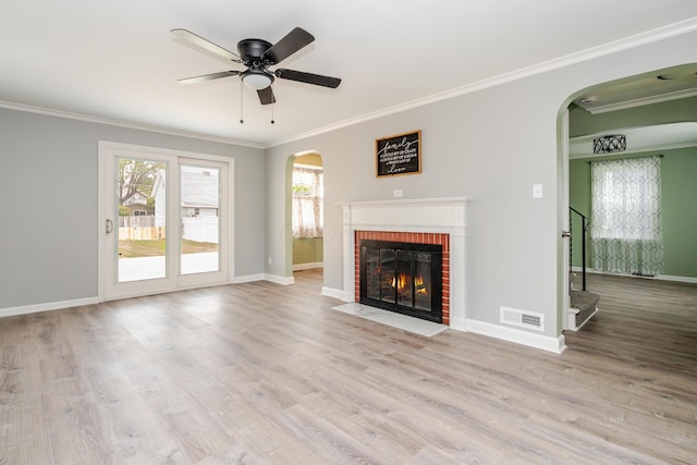 162 E Morrill Ave, Columbus, OH 43207 - unfurnished living room with arched walkways, crown molding, wood finished floors, baseboards, and a brick fireplace