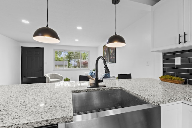 1530 Lexdale Dr, Reynoldsburg, OH 43068 - kitchen with a sink, white cabinetry, light stone counters, recessed lighting, and decorative light fixtures