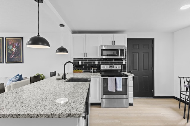 1530 Lexdale Dr, Reynoldsburg, OH 43068 - kitchen featuring appliances with stainless steel finishes, a sink, white cabinetry, decorative backsplash, and light stone counters