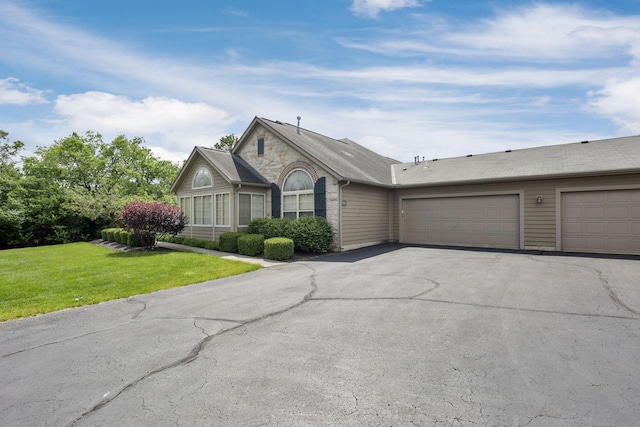 6542 Lakeview Cir, Canal Winchester, OH 43110 - ranch-style house with asphalt driveway, a front lawn, a garage, and stone siding