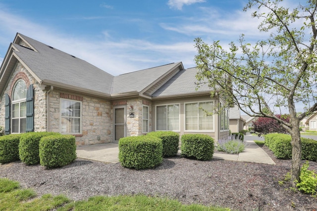 6542 Lakeview Cir, Canal Winchester, OH 43110 - view of front of house with stone siding, a shingled roof, and a patio