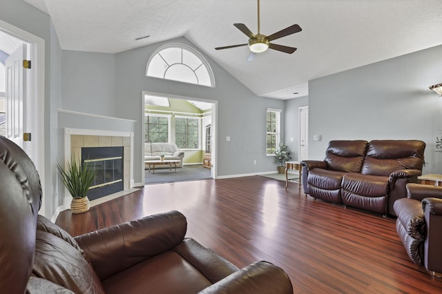 6542 Lakeview Cir, Canal Winchester, OH 43110 - living area featuring ceiling fan, wood finished floors, a tiled fireplace, high vaulted ceiling, and baseboards