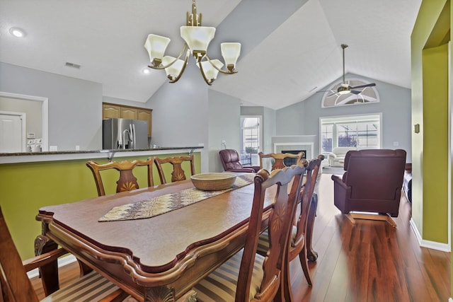 6542 Lakeview Cir, Canal Winchester, OH 43110 - dining room featuring vaulted ceiling, dark wood finished floors, a ceiling fan, a fireplace, and a chandelier