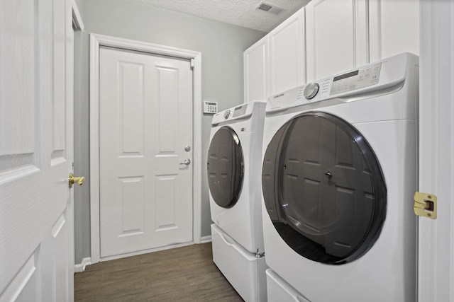 6542 Lakeview Cir, Canal Winchester, OH 43110 - laundry area featuring washer and clothes dryer, cabinet space, dark wood-style floors, and a textured ceiling