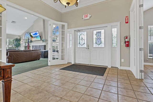 6542 Lakeview Cir, Canal Winchester, OH 43110 - entryway with light tile patterned floors, french doors, a tiled fireplace, plenty of natural light, and high vaulted ceiling